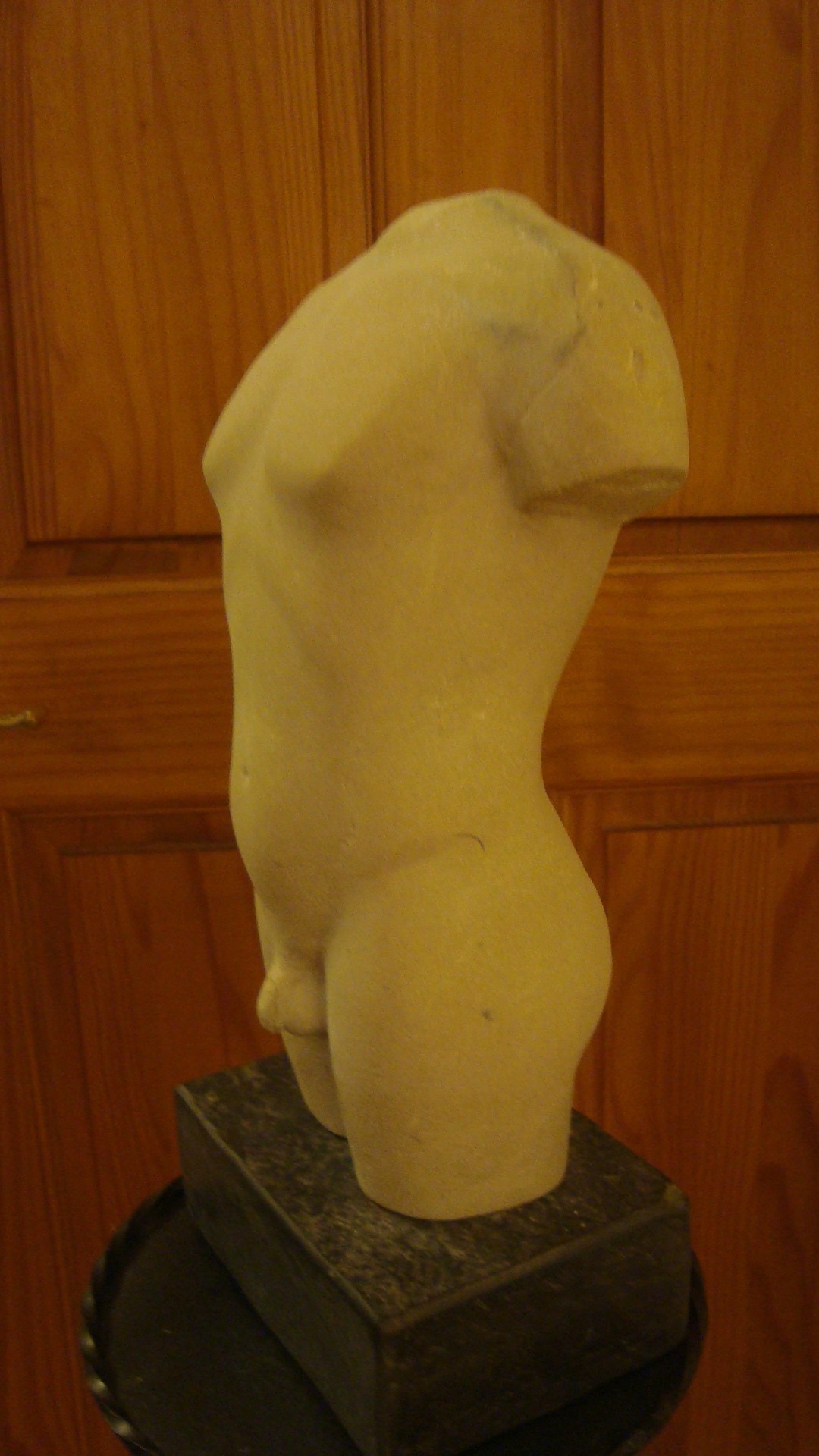 Carving of torso in white side view